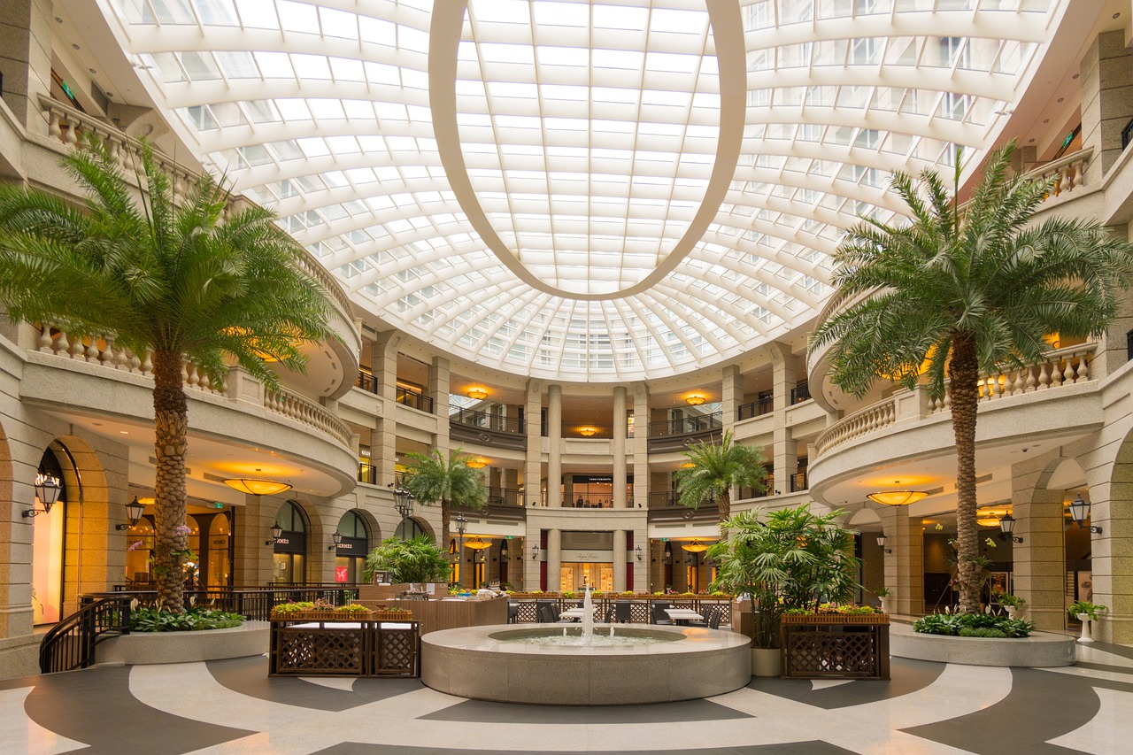 A large building with a fountain and palm trees