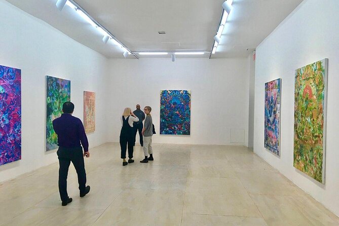 A group of people looking at art on the wall