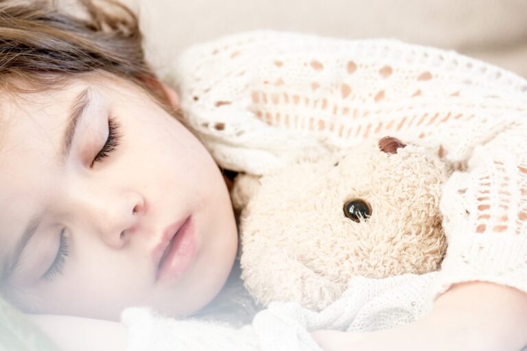 A girl sleeping with a teddy bear